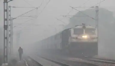 Dense foggy railway train in Seamanchal Live, India, showing a train approaching through mist.
