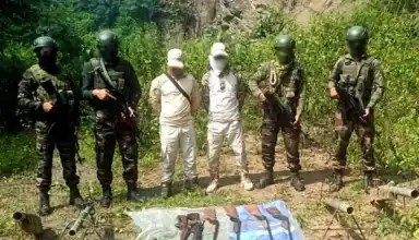 Armed security forces with weapons and equipment during a tactical operation in a rural setting.